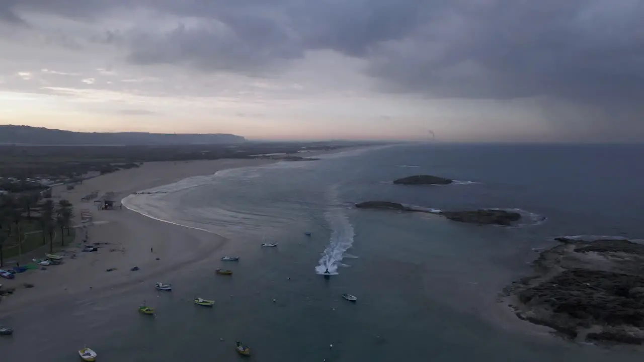 Aerial shot of a jet ski sailing through anchored boats at Hof Dor Israel