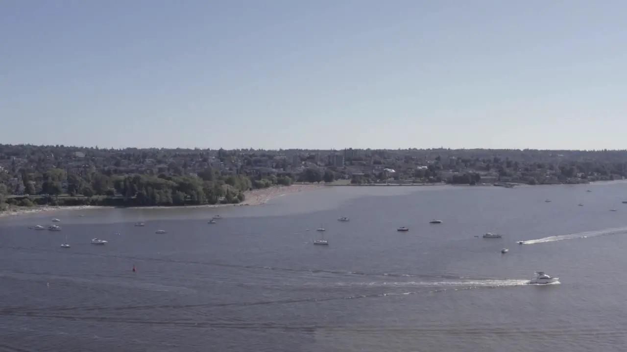 Aerial fly over from English Bay to Kitsilano Beach on a hot summer day as boaters relax suntan liesure beach activity motor boats zip by sails partying romantic fun fishing at the tropical ocean 5-7