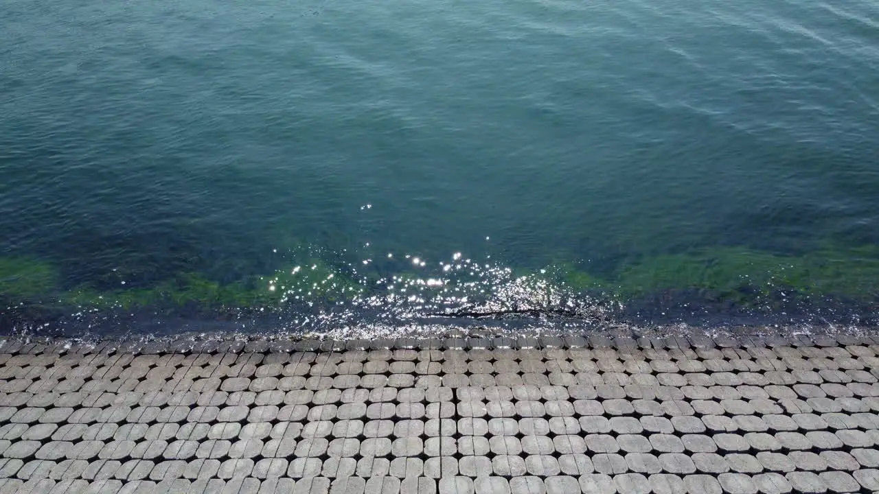 Shore bank with calm water slow motion aerial shot