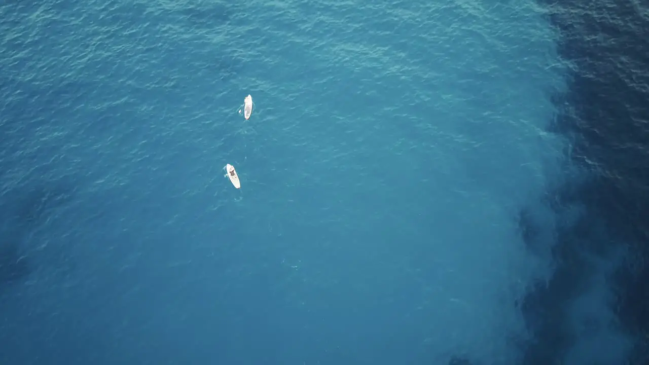 Drone footage of stand up paddling in clear blue turquoise water