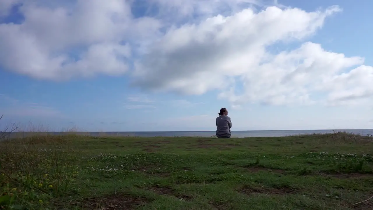 Woman Sitting on a Cliff