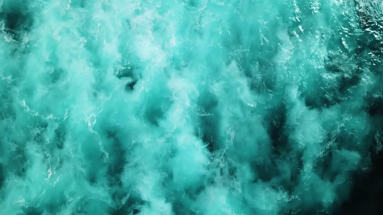 Aerial shot directly above the choppy white-wash ocean waters on a stormy day in the Pacific Ocean