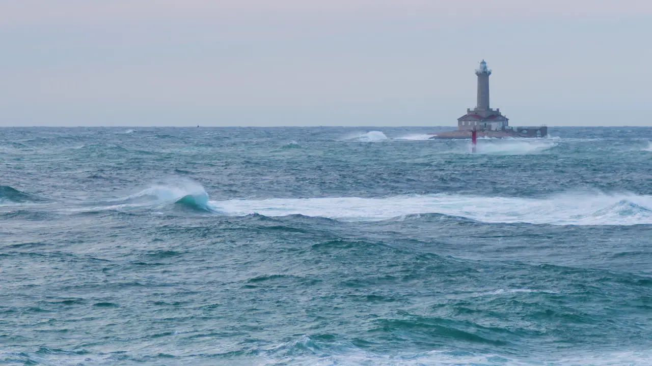 Lighthouse Porer on stormy weather big waves making crests grebes flying through restless sea