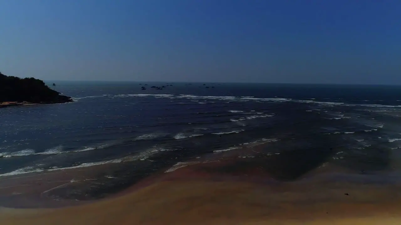 Drone footage moving forwards towards sea and hills touching the waves  shot in south GOA India