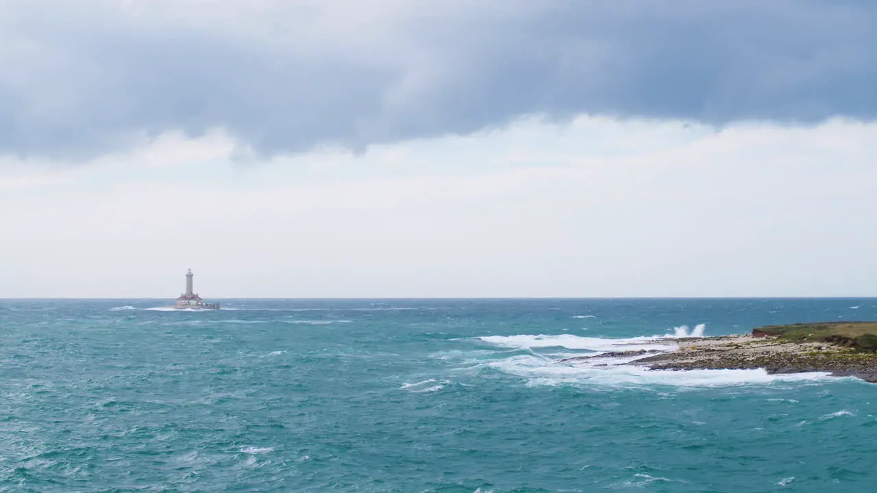 Lighthouse Porer and Fenoliga island under big waves on stormy weather restless sea seagulls flying