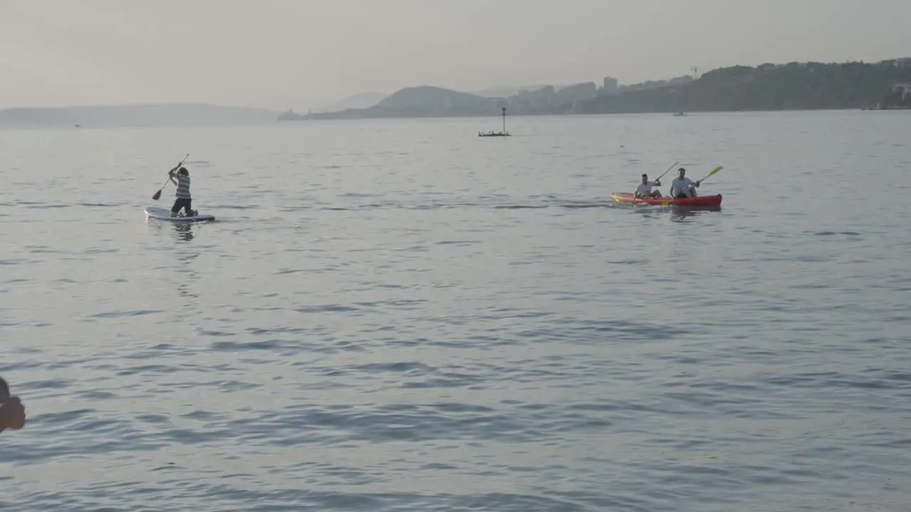 The coach waves to the rowers in the beautiful sea