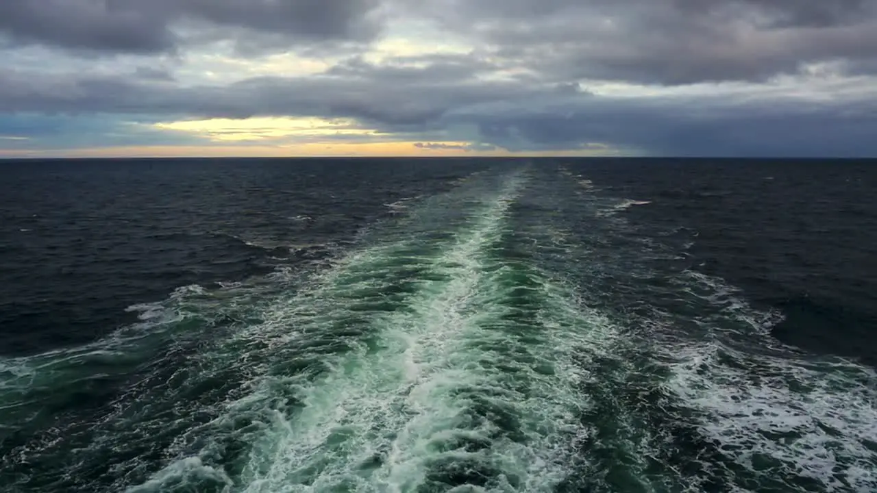 View of ship's wake trailing into a cloudy golden sunset at sea between Prince Edward Island and La Baie