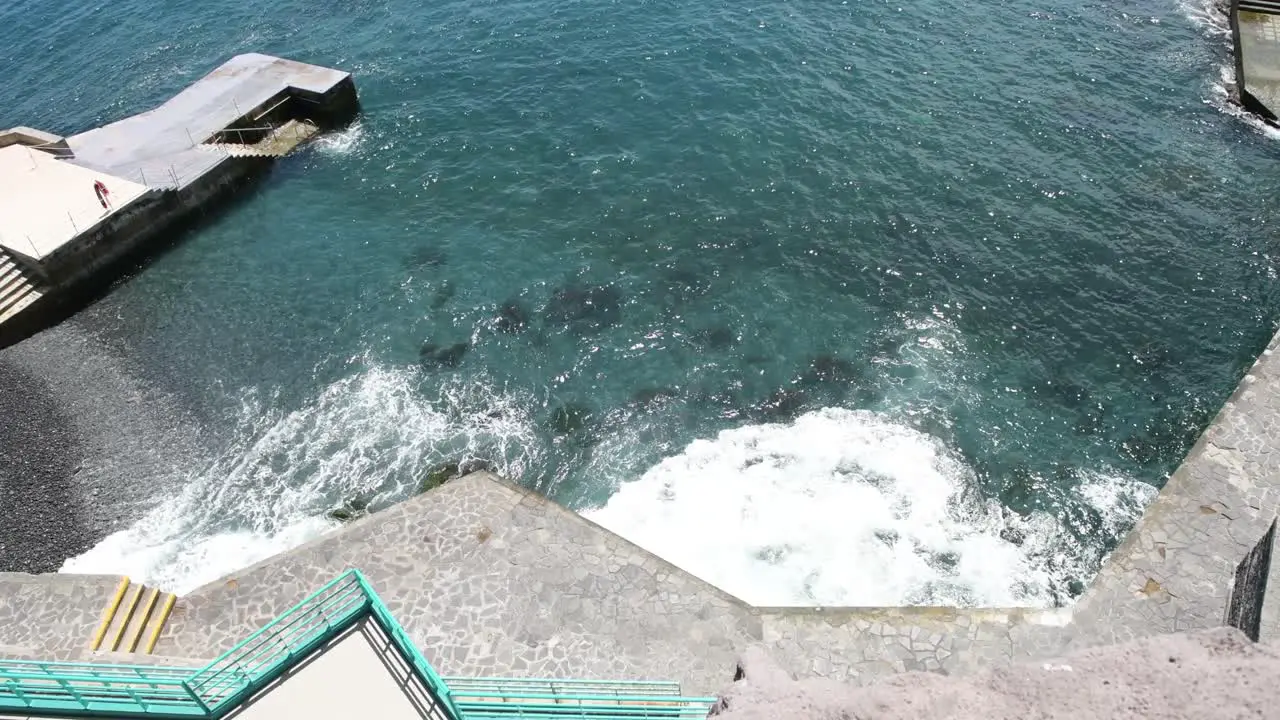 Above shot of beach with crashing waves on a black stone beach