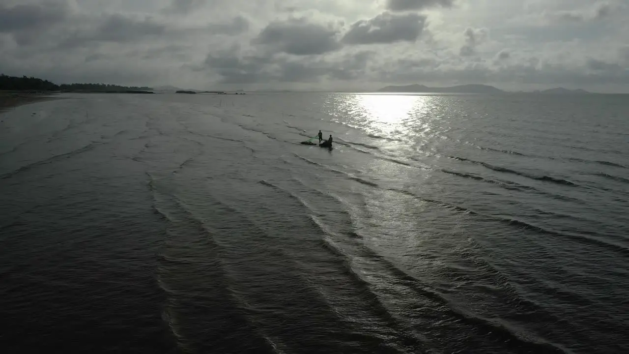 Morning aerial view with interesting light of fishermen collecting clams in shallow water in Can Gio Salt fields Vietnam