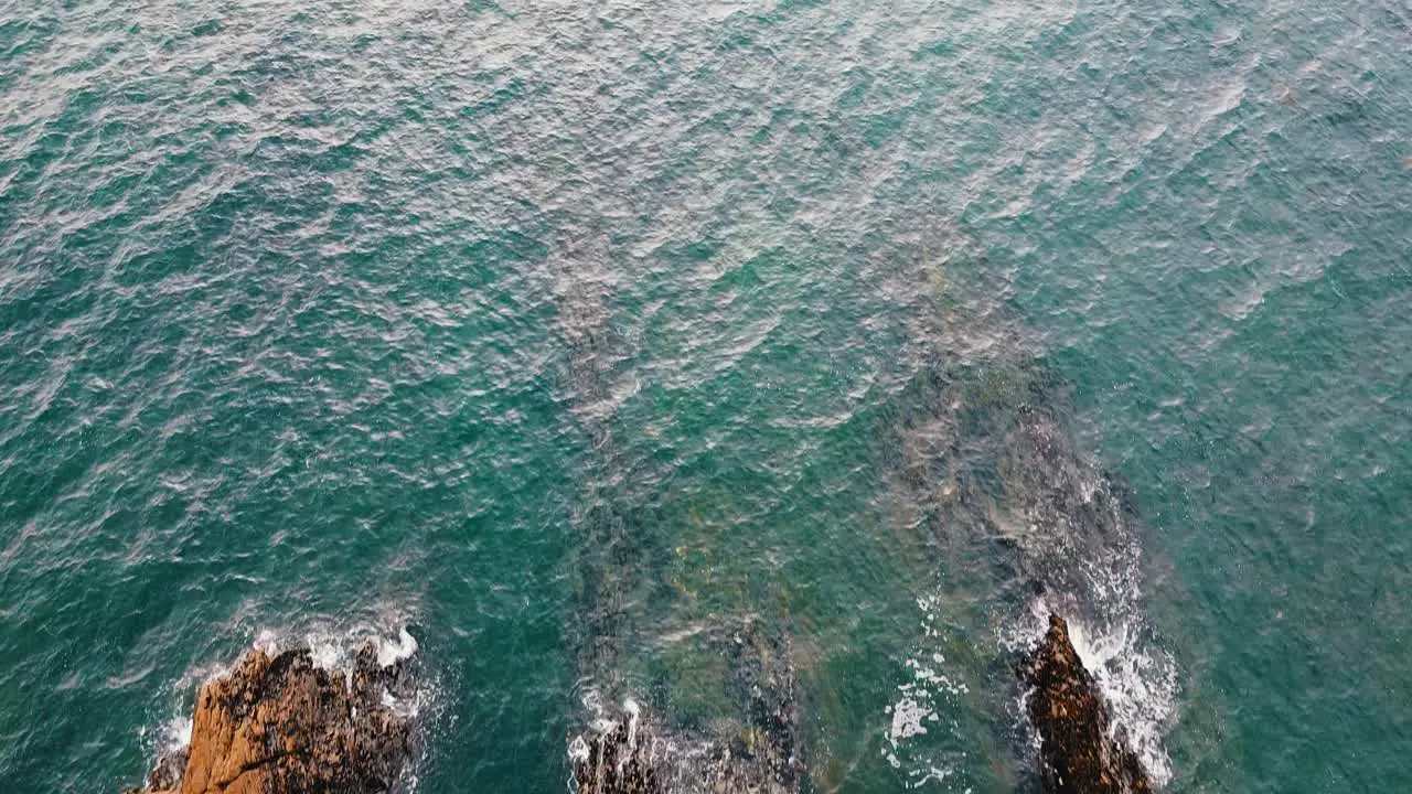 Top aerial drone view of ocean waves crash against rocks in Brittany France Bretagne