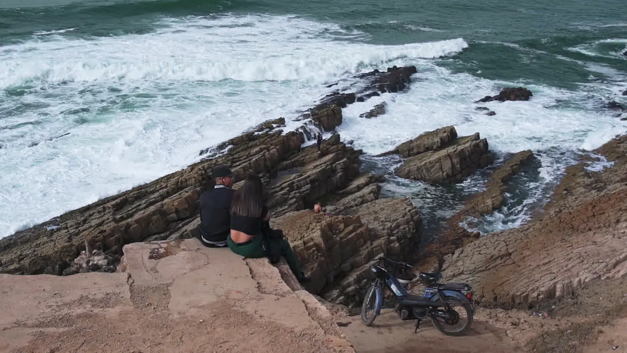 Young Moroccan couple sitting by the ocean in Casablanca Morocco