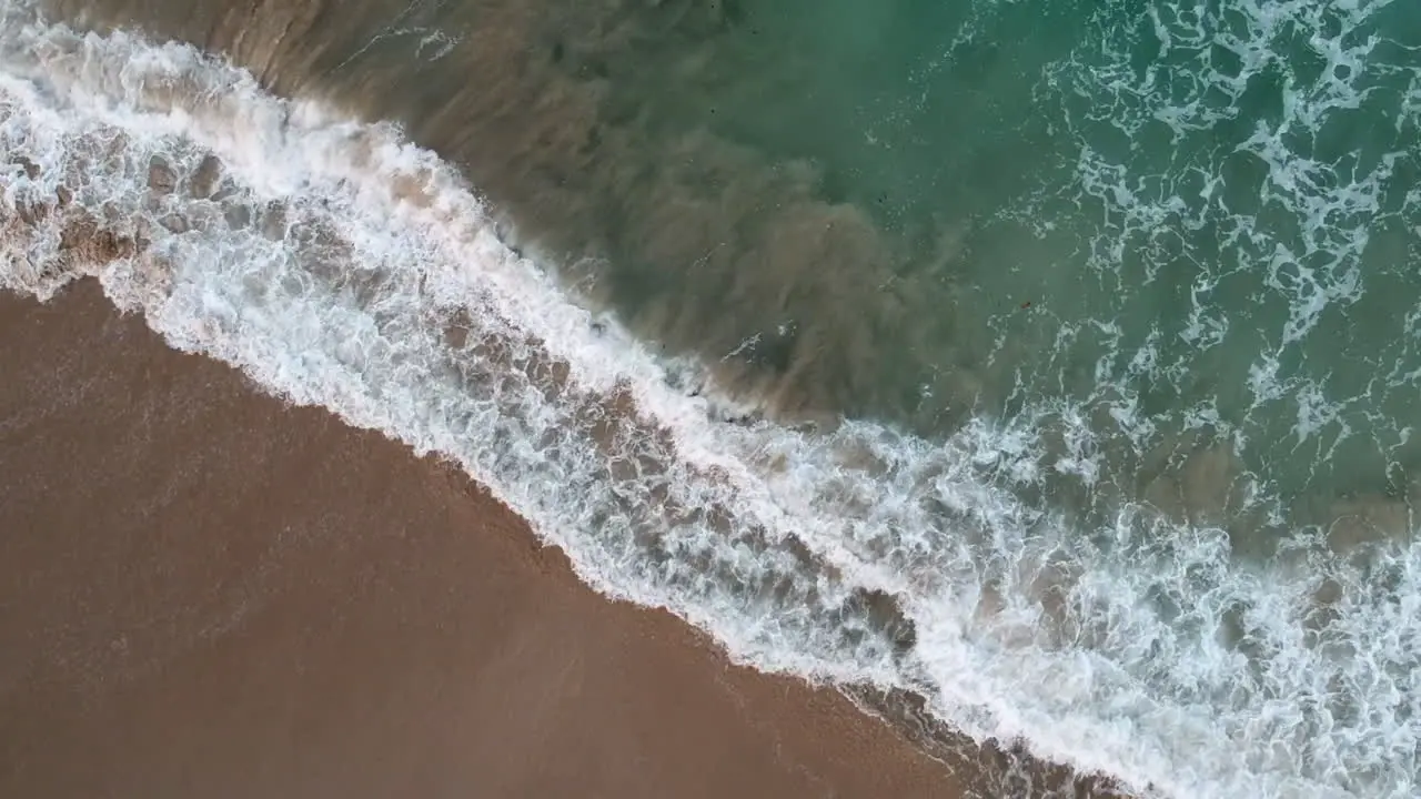 Topdown View Of Foamy Breaking Waves From Turquoise Ocean