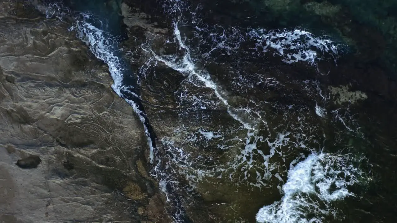 Aerial drone footage of sea waves hitting the cliff