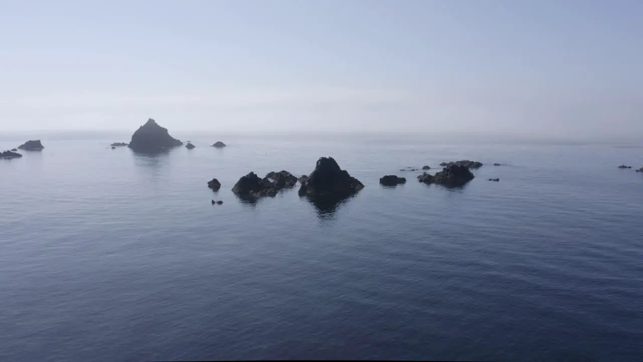 Small jagged rocks in shallow ocean water present navigation hazard