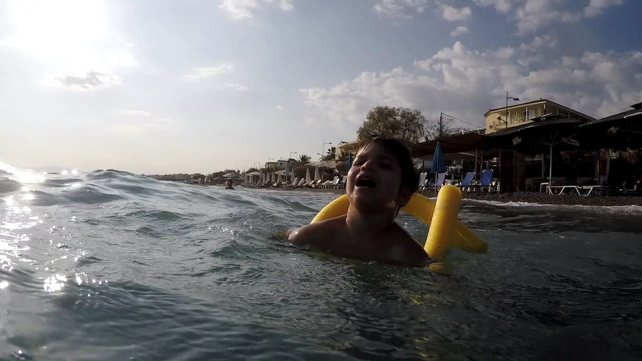 Footage of Caucasian boy having fun with waves at Kalamata beach Greece