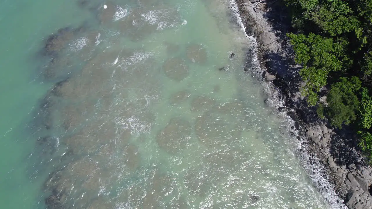 Clear Blue Sea With Waves Splashing Onto The Shore In Tropical North Queensland Australia