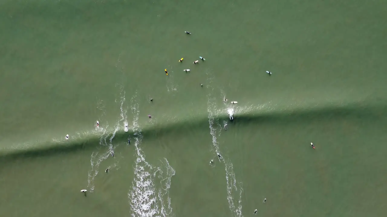 surfer at the point of the reef-break les grenettes on the island of Ré in France from above with the drone wave is moving