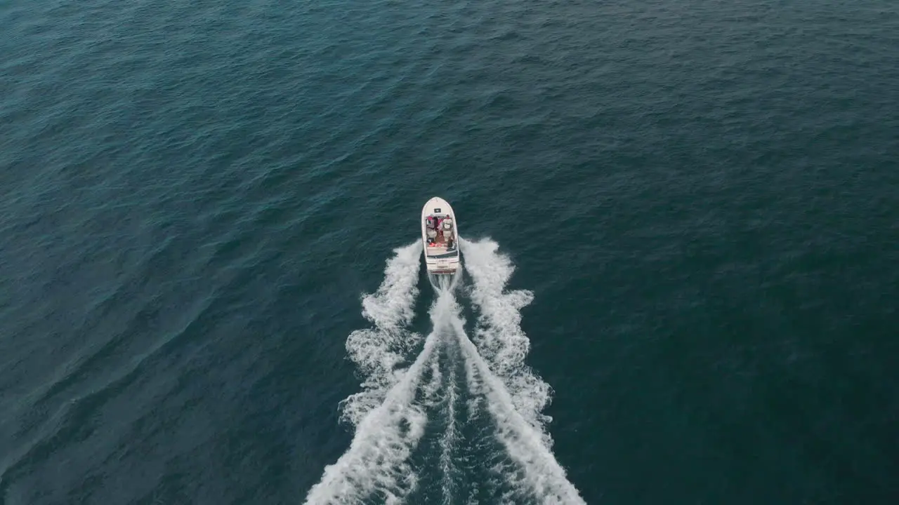 Aerial shot with a drone following a boat in the ocean