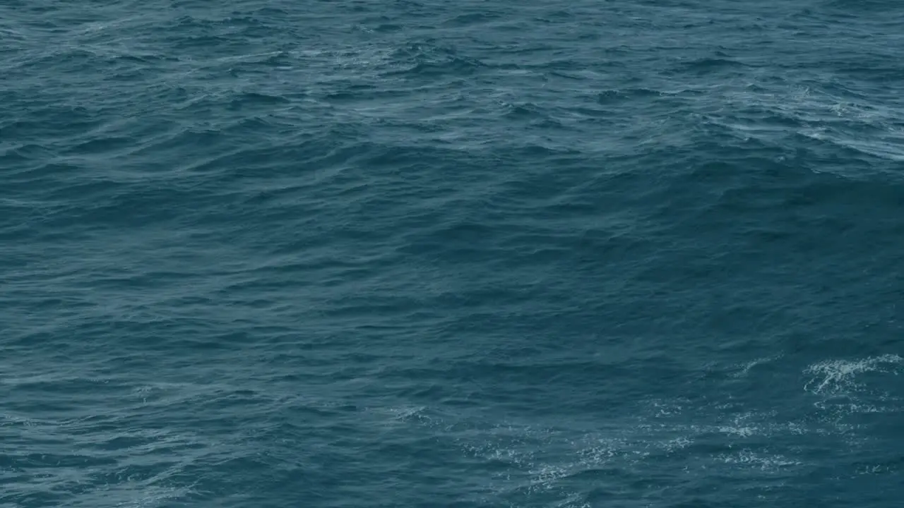 Cinematic aerial shot of dark blue ocean surface moody sea waves deep ocean