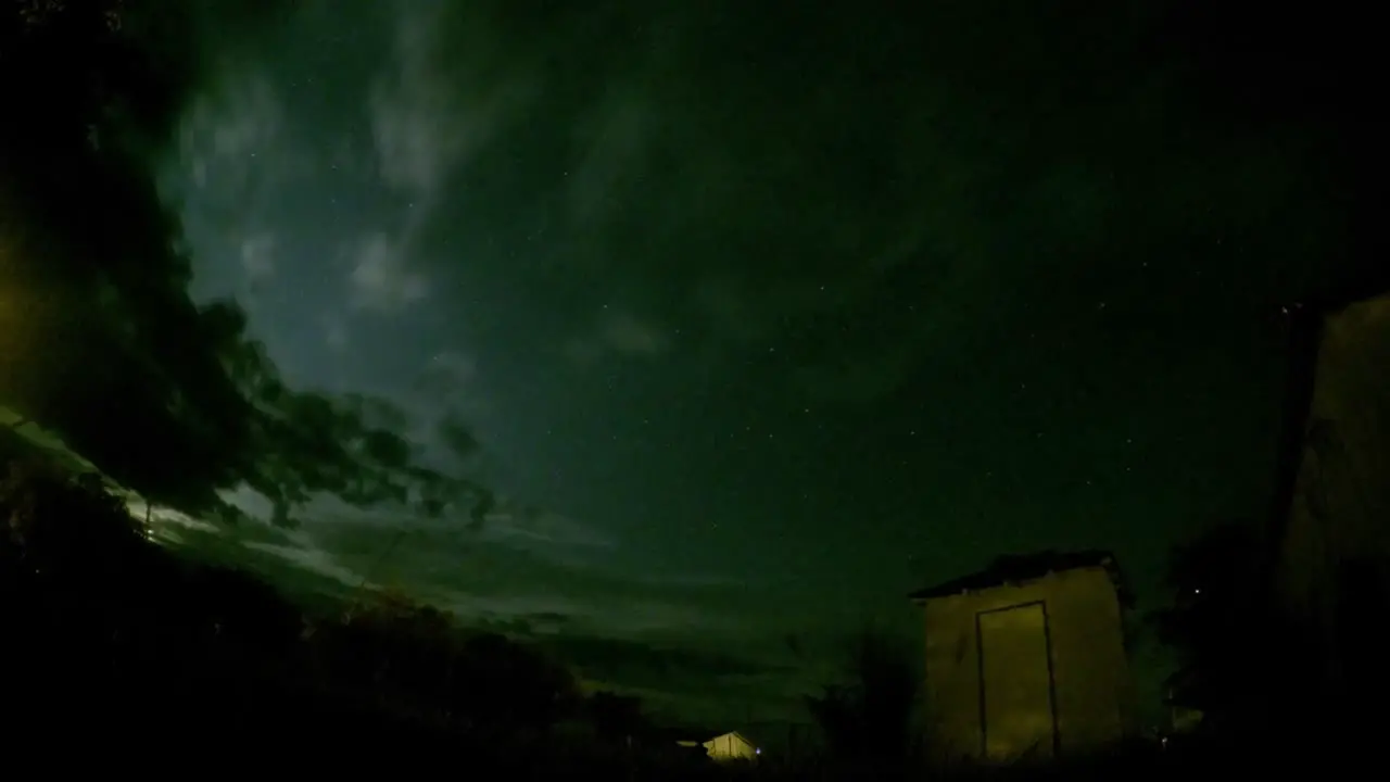 NIGHT LAPSE Stars clouds field and abandoned building