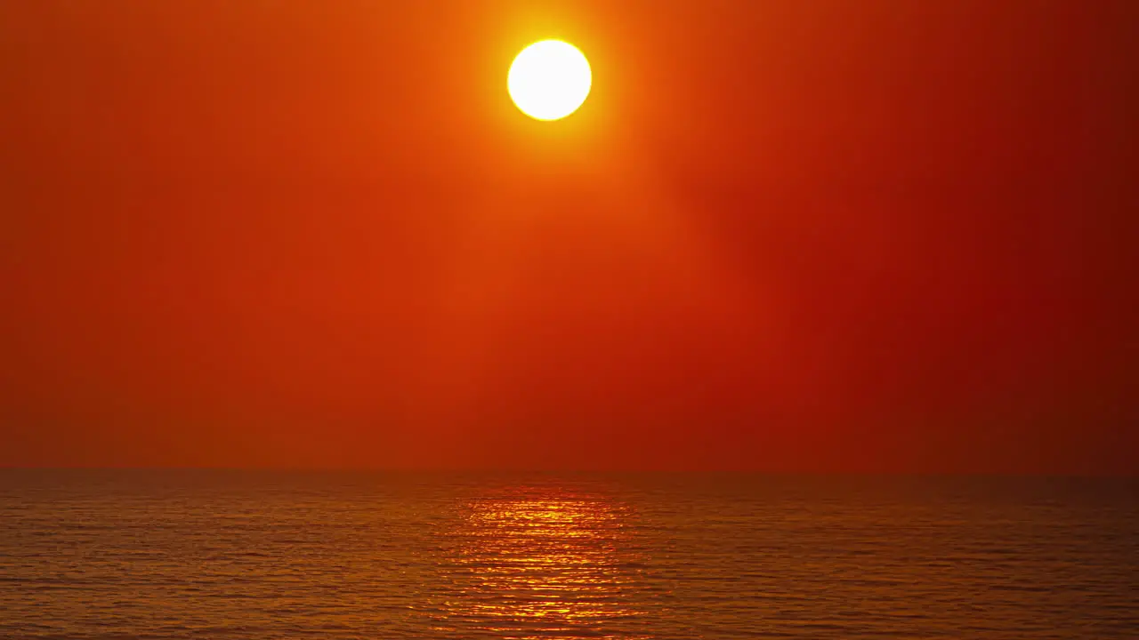 Timelapse shot of the sun coming down over the horizon in the background over the ocean during evening time