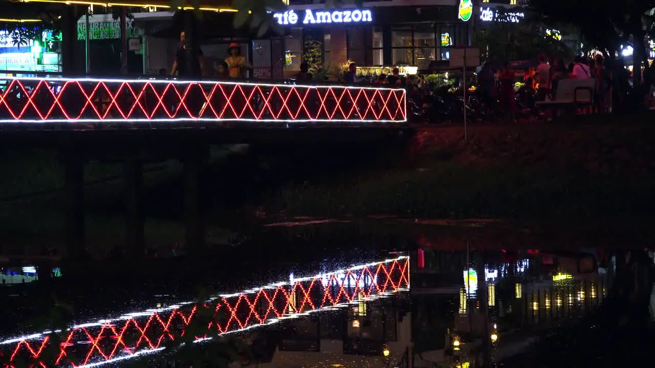 Peoples Walking on an Illuminated Bridge