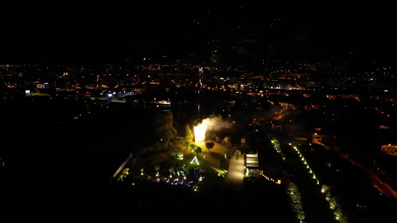 Drone shot of fireworks over city at night