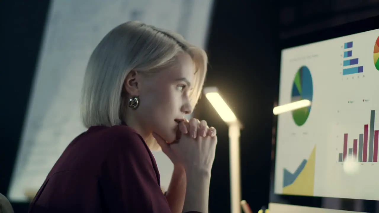 Pensive business woman analyzing charts on computer in night office