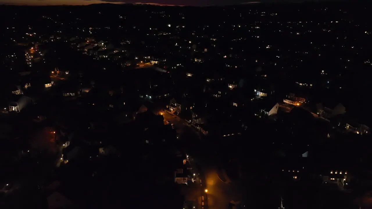 Aerial tilt up reveal of houses in large sprawling American neighborhood during sunset dusk