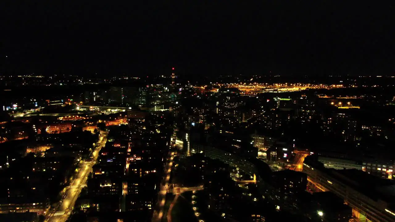 A smooth approaching and descending aerial shot on Helinski Finland as a train passes through the city in the distance