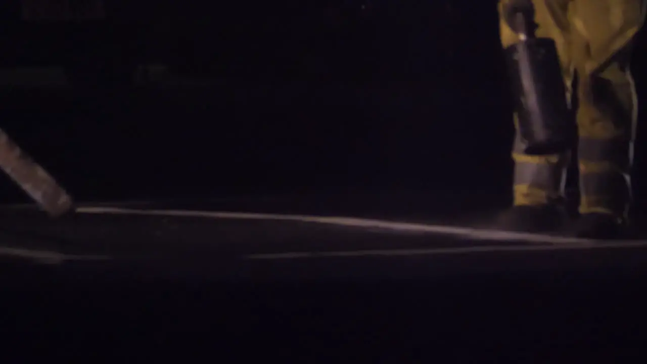 Unrecognizable road workers line painting on a main road in the UK at night in slow motion