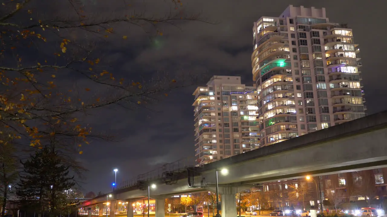 Trains Running On The Railway Over Busy Streets In Downtown Vancouver At Night low angle time lapse