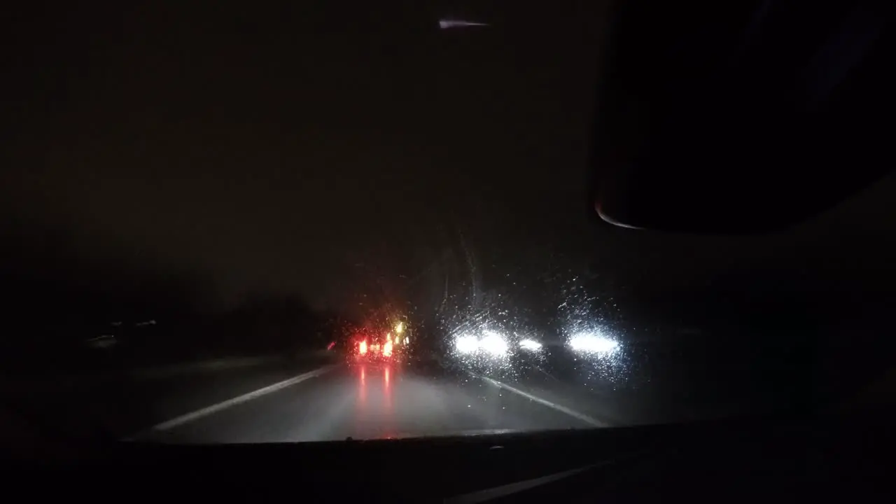 Timelapse shot of a car's nighttime drive on a road with lights and other vehicles