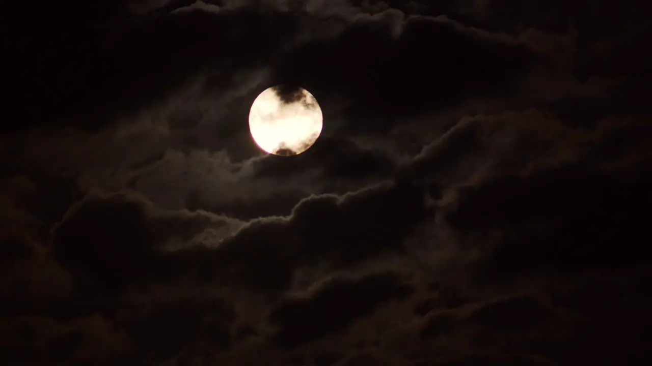 Moon rising through clouds time-lapse