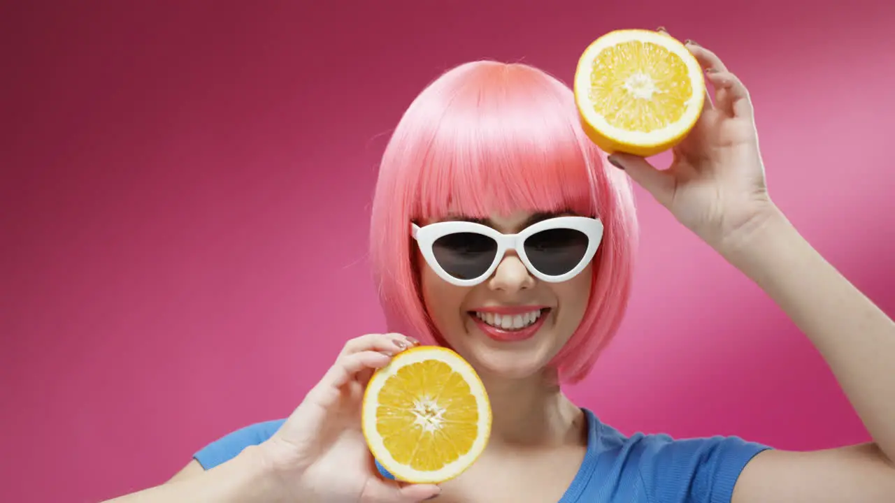 Close Up Of Woman Wearing Sunglasses And A Pink Wig Closing Eyes