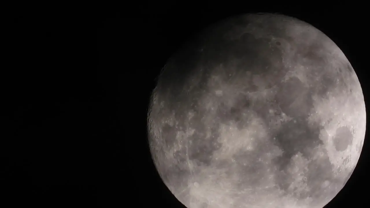 Zoomed in big full Moon is floating on black night sky dramatic dark clouds passing over timelapse