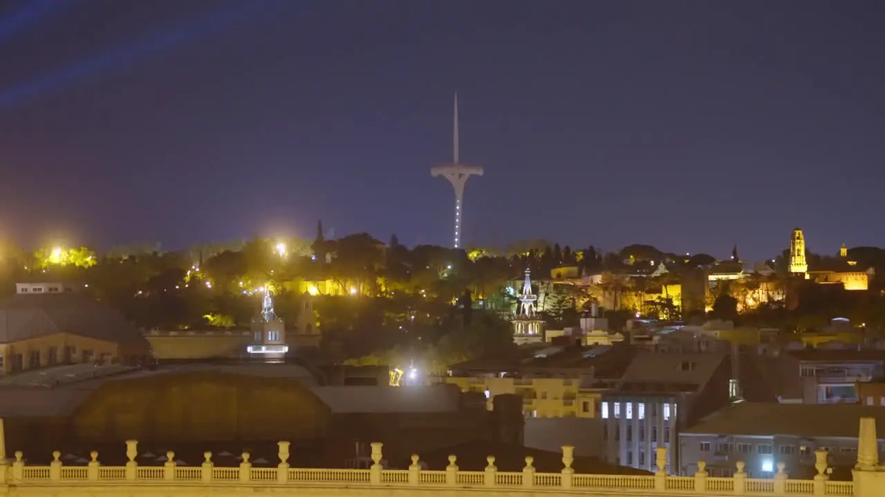 Famous torre telefonica Calatrava flashing above Barcelona by night