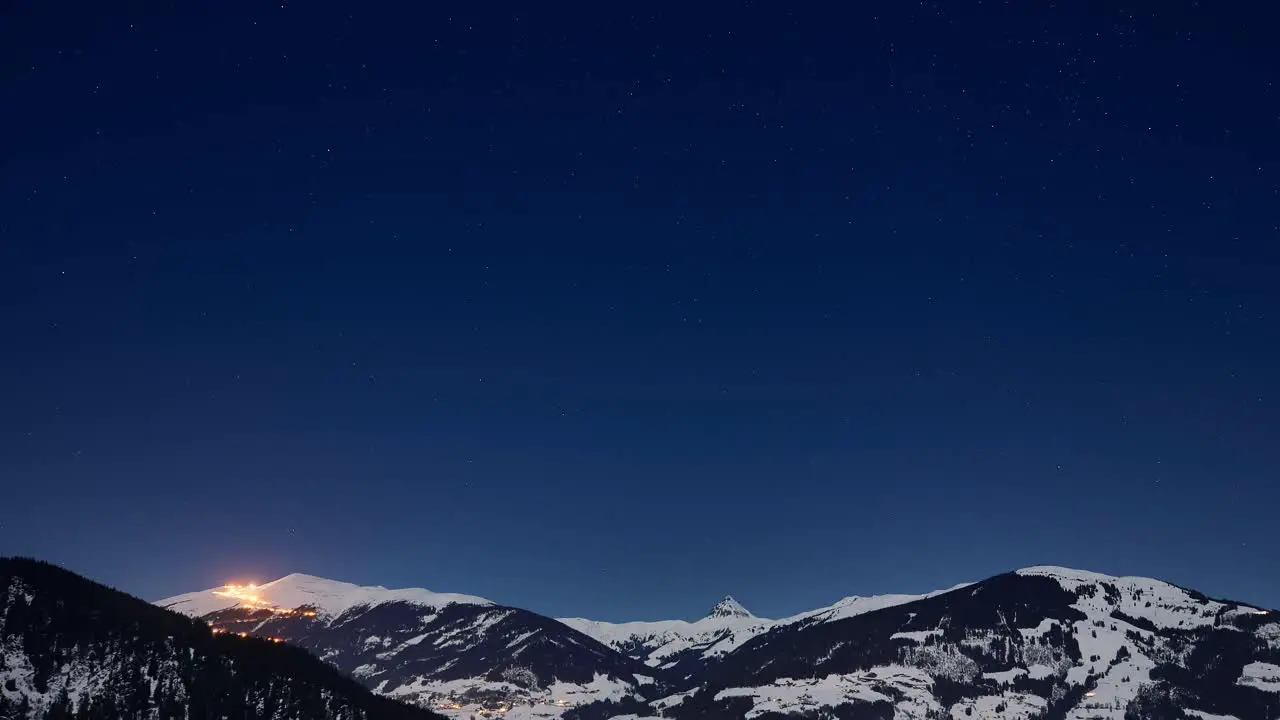 Time lapse of a crystal clear starry sky over snowy ski resort