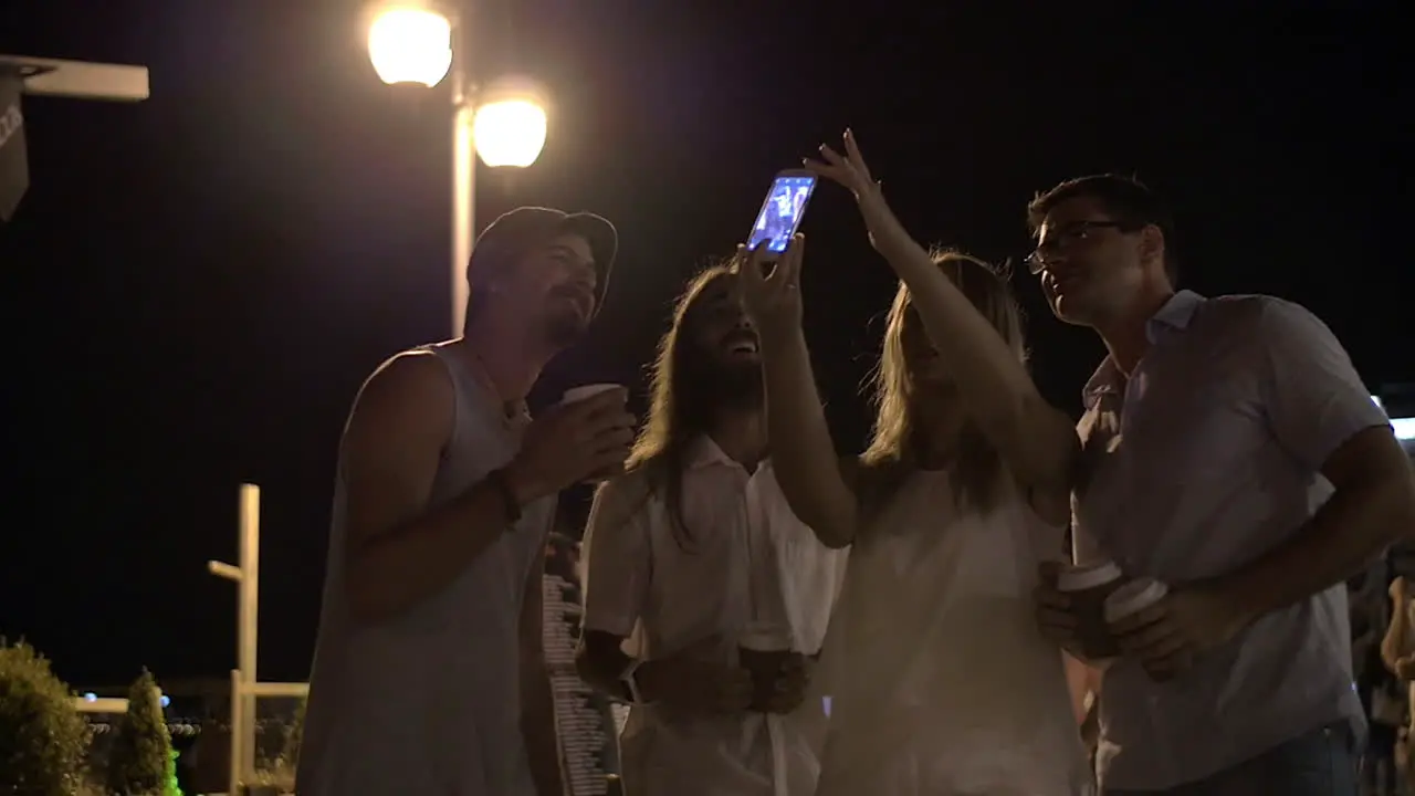 Friends making mobile selfie in night street