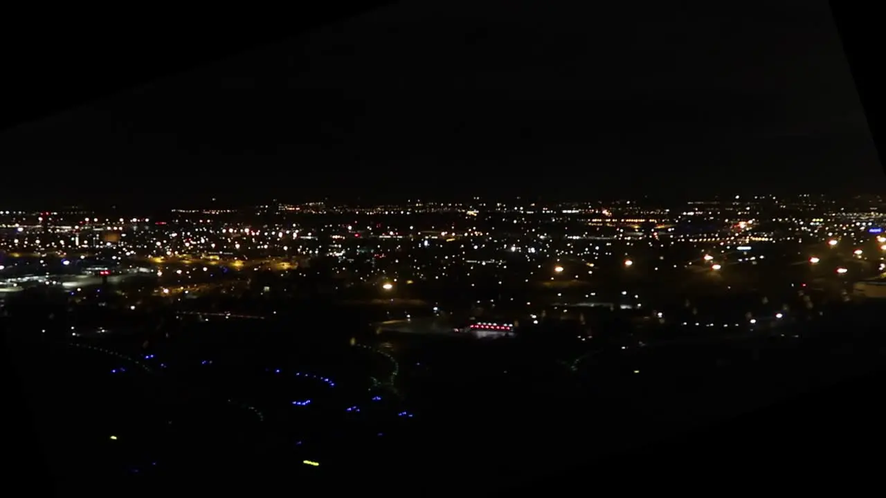 view from an airplane window during takeoff at night with city lights