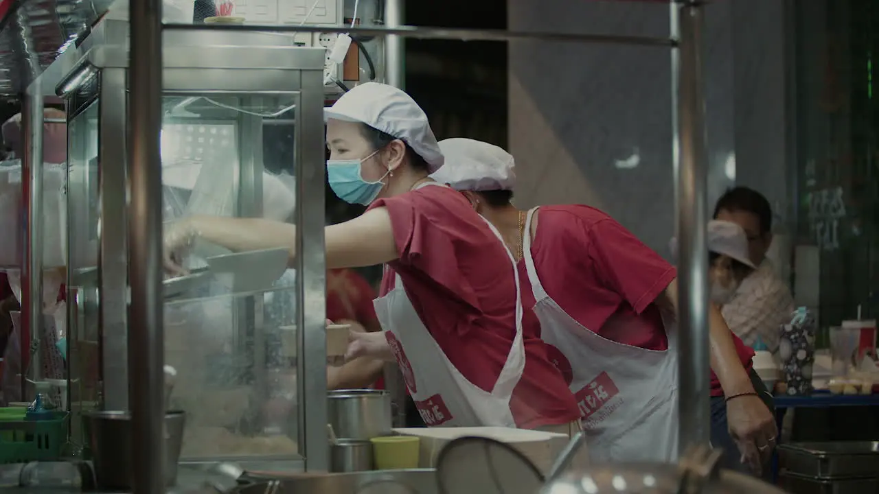 Busy Street Food Vendors preparing Noodle Dish at Night Bangkok Street Food Noodle Stall at Night