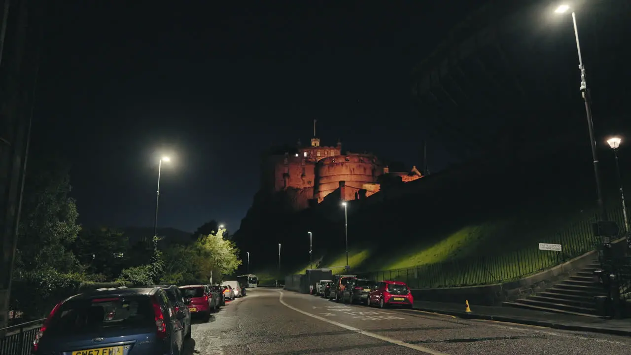 Edinburgh Castle lit up at night from a city street