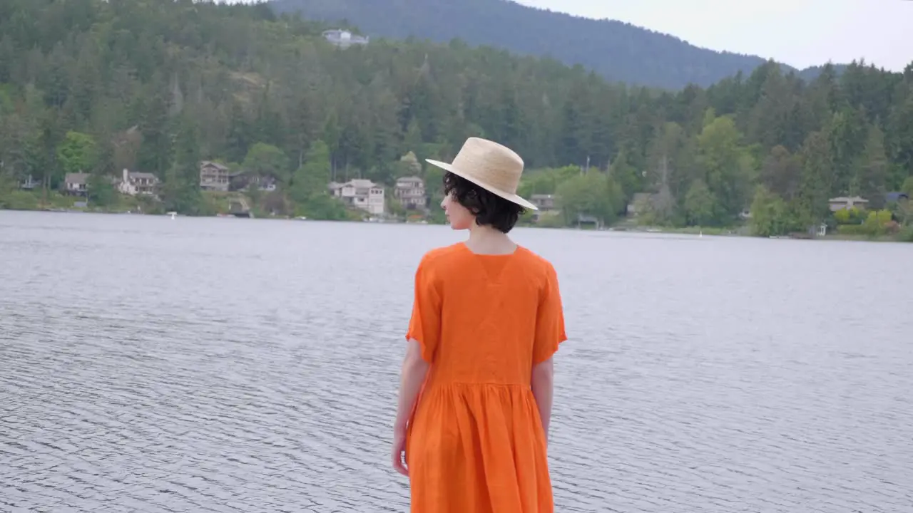 Adult Woman in Bright Orange Dress Walking Out to the Lake