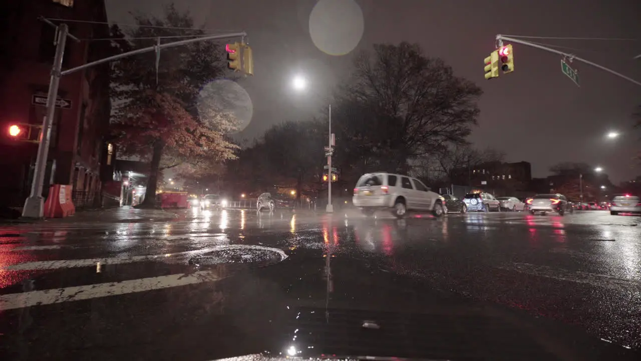 Car Going Through Rain Puddle in City at Night and Car Running Red Light