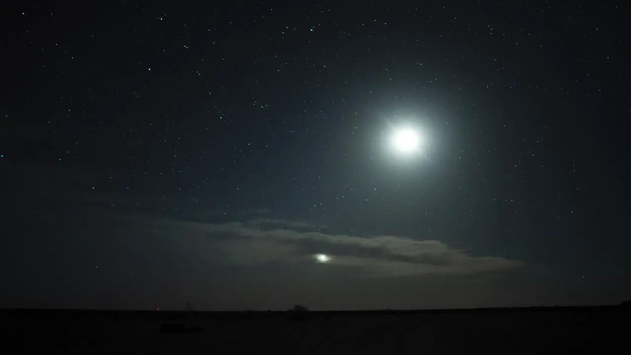 Timelapse of sunset at twilight going into the night with clouds moon and the northern star