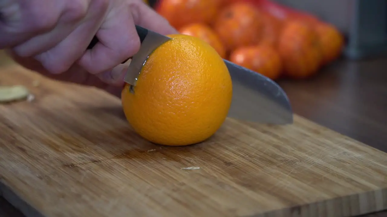 Chopping juicy orange on cutting board organically