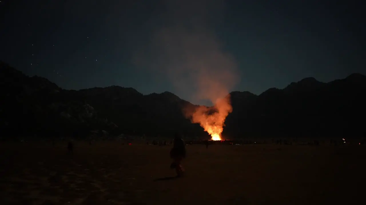 Night scene with big campfire and people wondering stars night sky camping