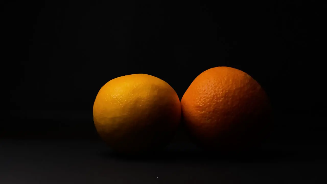 Static shot of woman hand pick up orange fruit black background