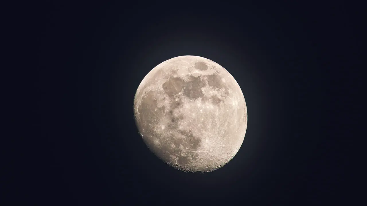 Moon with its maria and craters shining bright in night sky