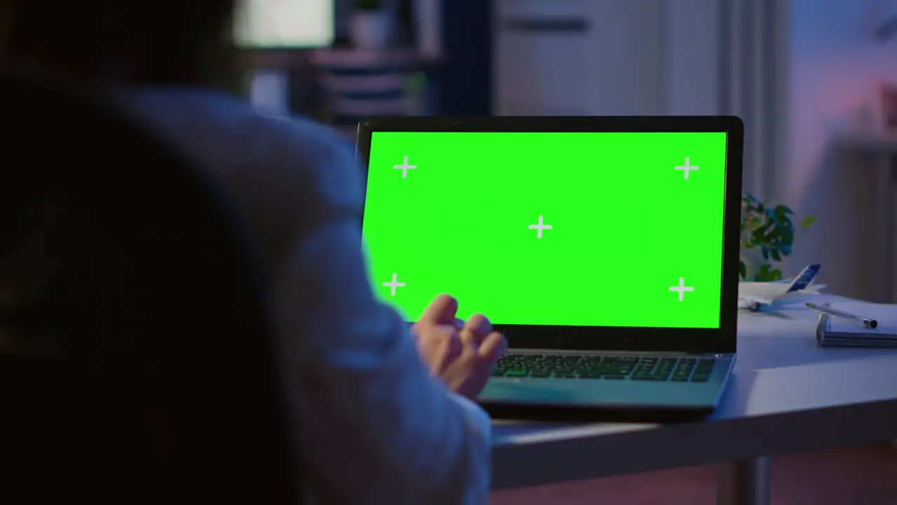 Close up of freelancer typing on laptop with green screen overtime